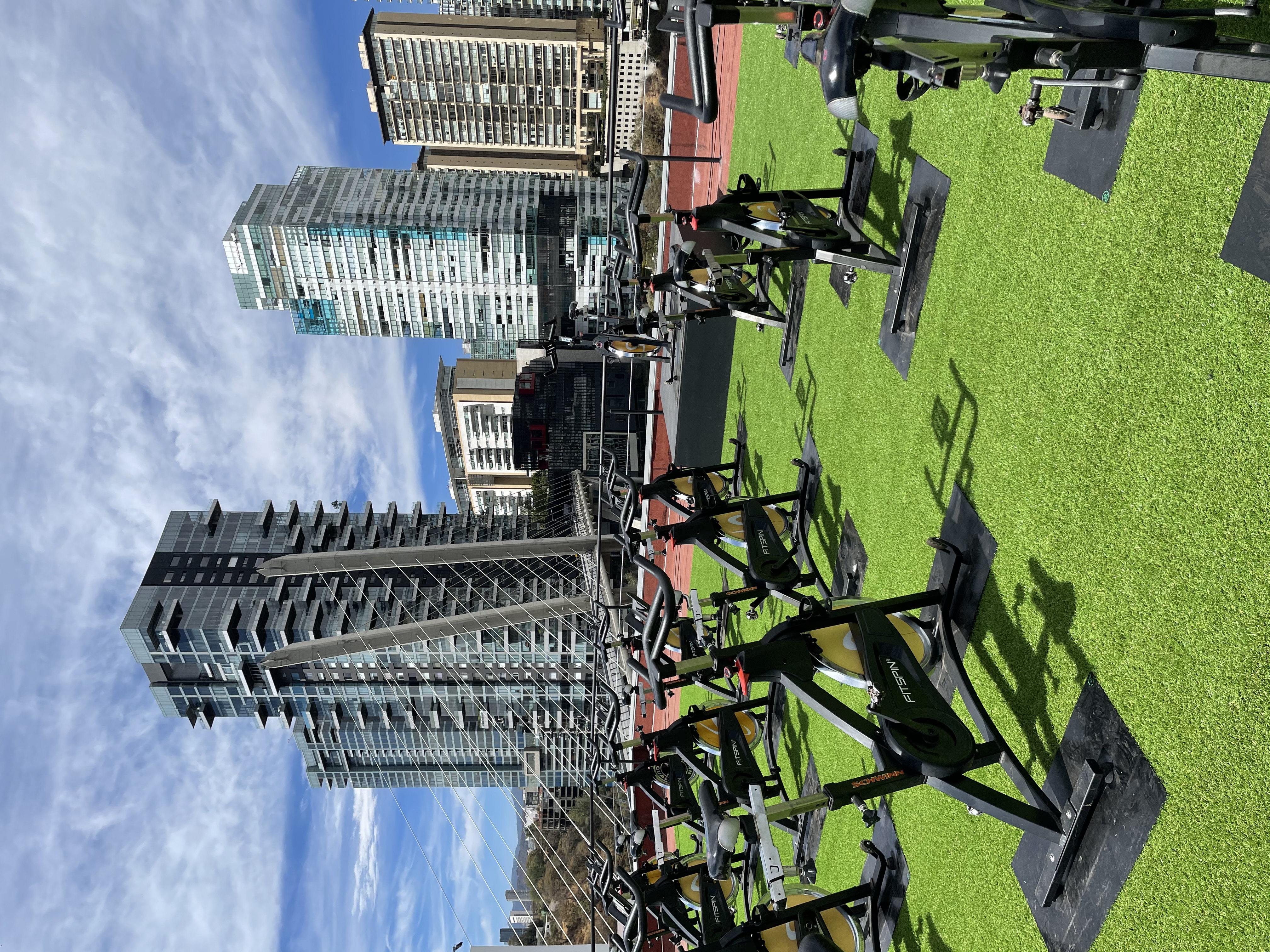 Bicicletas Fitspin en una terraza al aire libre con vista a la ciudad.